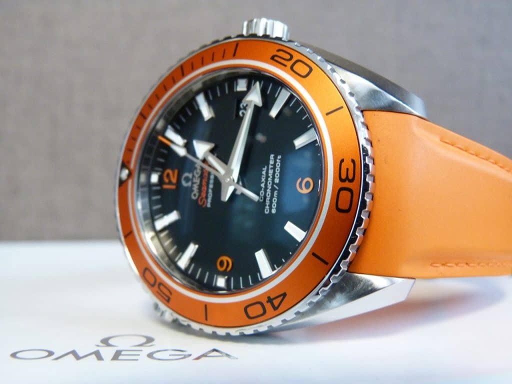 Orange Omega Seamaster watch laying on a box